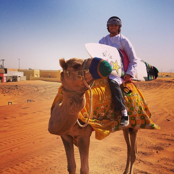 Matt Meola riding a camel on his surf trip to Wadi Adventure Wave Pool