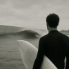 The silhouette of a surfer looks at a human-made wave