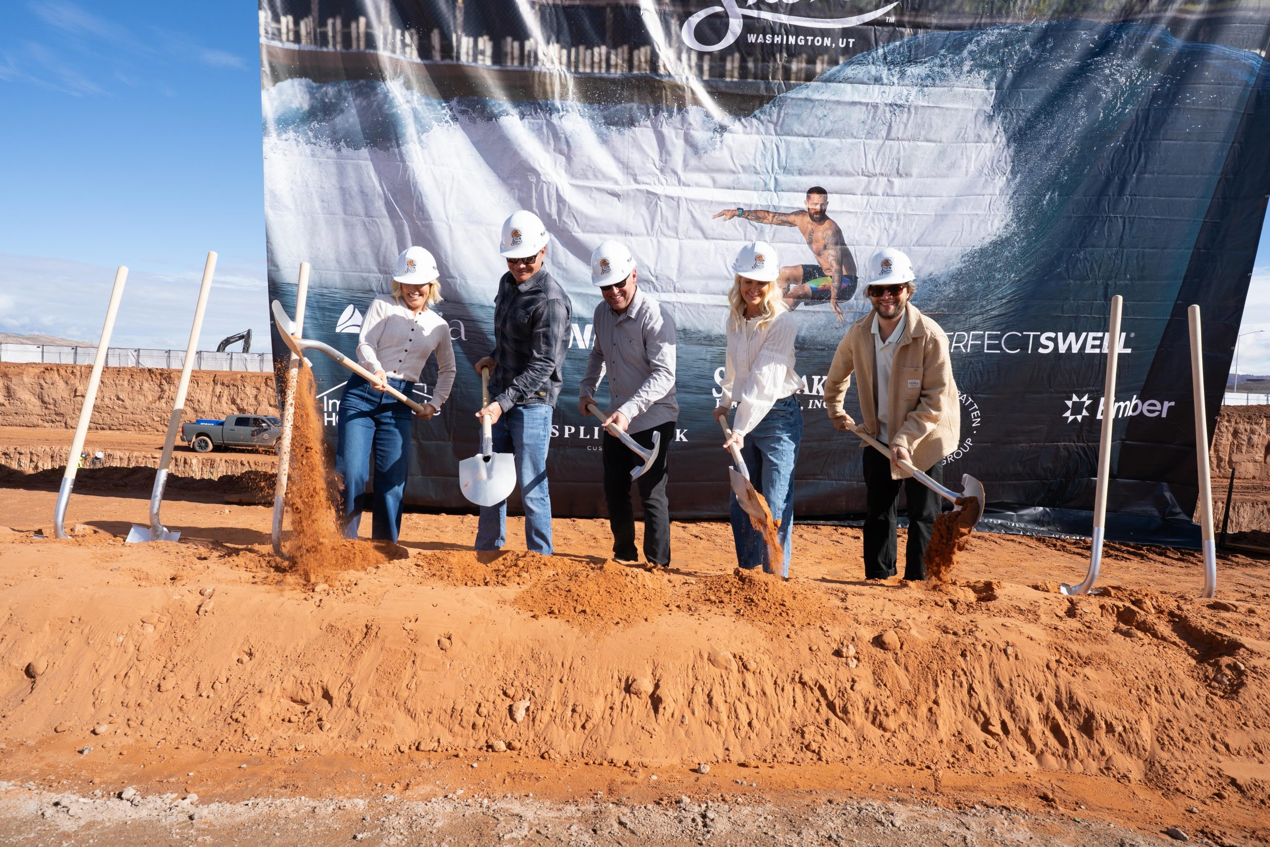 people with shovels dig into red dirt